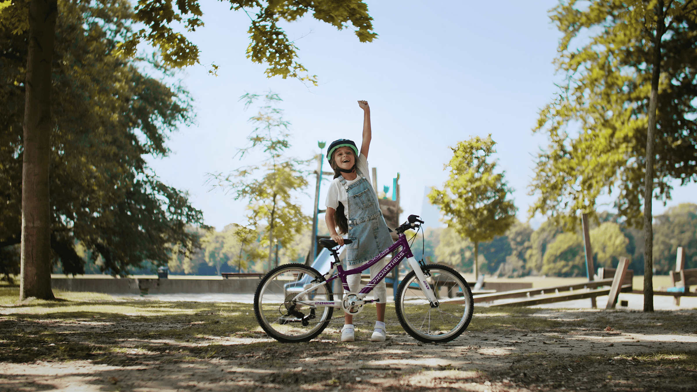 Glückliches Kind mit Fahrrad und Helm im Park – Outdoor-Aktivität für Kinder, sicher und aktiv Radfahren lernen.