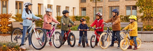 Kinder mit Fahrrädern im herbstlichen Nachbarschaftshof